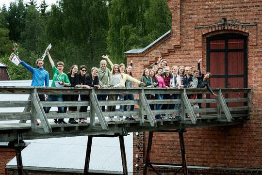 Glade ungdommer på en bru på Klevfos industrimuseum.  
